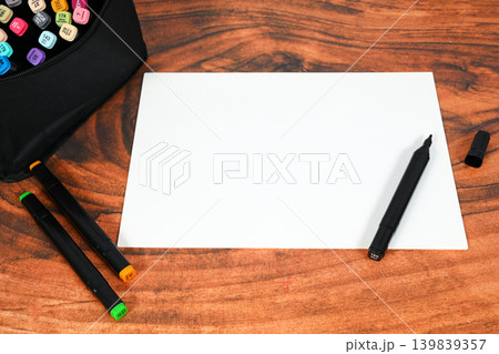 sketch sheet on a wooden background with a black marker without a cap and colored felt-tip pens sketch sheet on a wooden background with a black marker without a cap and colored felt-tip pens 139839357
