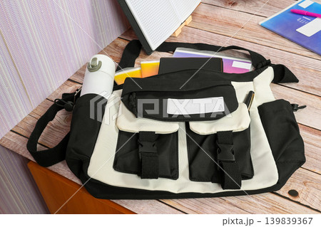 black and white fabric bag with school supplies on a desk black and white fabric bag with school supplies on a desk 139839367