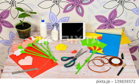 student workspace with paper flowers and a gadget student workspace with paper flowers and a gadget 139839372