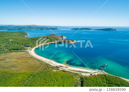 Expansive aerial perspective reveals a beautiful bay with clear turquoise water meeting a sandy beach Expansive aerial perspective reveals a beautiful bay with clear turquoise water meeting a sandy beach 139839590