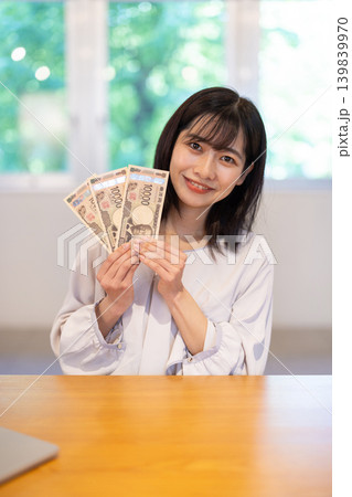 3枚の1万円札を手に微笑む日本人の若い女性 3枚の1万円札を手に微笑む日本人の若い女性 139839970