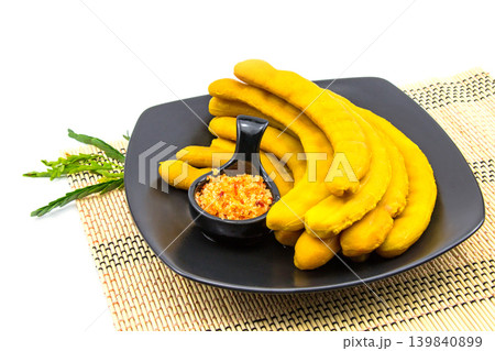 Pickled tamarind preserved in syrup on a black ceramic plate It is isolated on a white background. 139840899