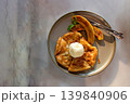Banana roti topping with vanilla ice cream is arranged on a modern style plate on the table. Top view. 139840906