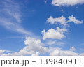 A beautiful blue sky filled with soft clouds captures the calm and beauty of a sunny day. 139840911