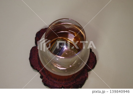 Glass of Amber Liquid on Wooden Coaster 139840946