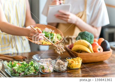 料理教室・クッキングスクールで料理を教える講師の女性と生徒の女性の手元 139841361