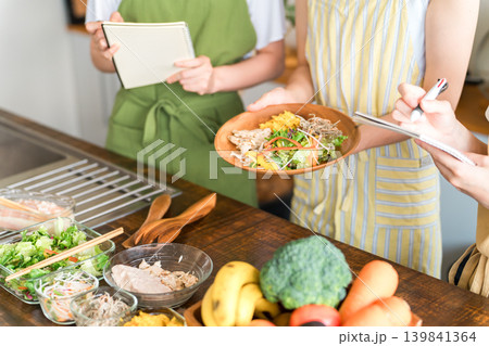 料理教室・クッキングスクールで料理を教える講師の女性と生徒の女性の手元 139841364