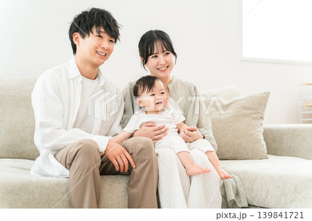 ソファに座り赤ちゃんを抱っこする若い家族,親子,ファミリー（子育て支援,少子化対策） 139841721