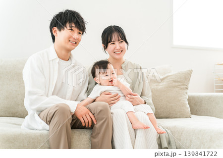ソファに座り赤ちゃんを抱っこする若い家族,親子,ファミリー(子育て支援,少子化対策) ソファに座り赤ちゃんを抱っこする若い家族,親子,ファミリー(子育て支援,少子化対策) 139841722
