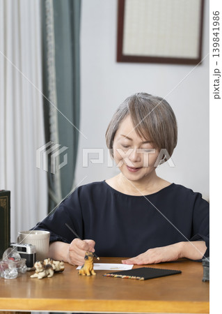 リビングで絵手紙を描くシニア女性 リビングで絵手紙を描くシニア女性 139841986