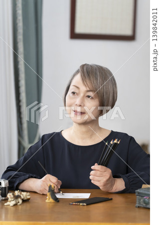 リビングで絵手紙を描くシニア女性 リビングで絵手紙を描くシニア女性 139842011