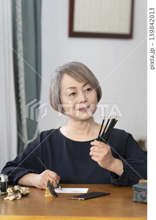 リビングで絵手紙を描くシニア女性 リビングで絵手紙を描くシニア女性 139842013