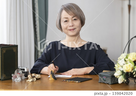 リビングで絵手紙を描くシニア女性 リビングで絵手紙を描くシニア女性 139842020