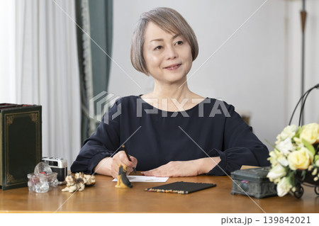 リビングで絵手紙を描くシニア女性 リビングで絵手紙を描くシニア女性 139842021