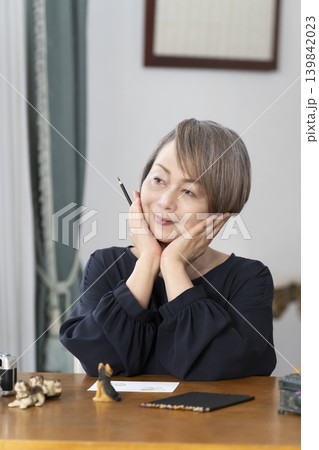 リビングで絵手紙を描くシニア女性 リビングで絵手紙を描くシニア女性 139842023