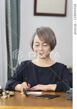 リビングで絵手紙を描くシニア女性 リビングで絵手紙を描くシニア女性 139842026