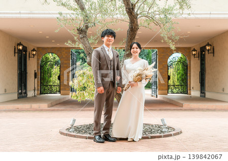 結婚式で結婚式場の庭でブーケを持つ新郎新婦（ガーデンウェディング） 139842067