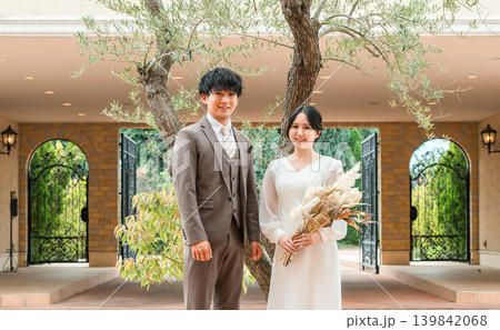 結婚式で結婚式場の庭でブーケを持つ新郎新婦（ガーデンウェディング） 139842068