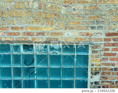Exploring the textured wall with glass blocks at an outdoor location in a city under bright daylight 139842286