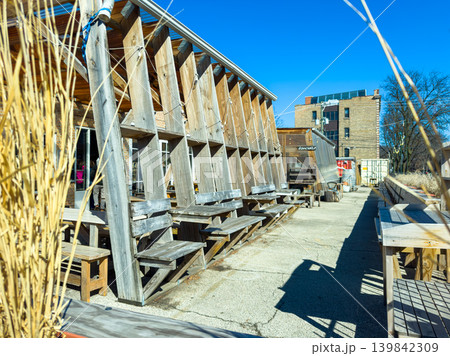 Outdoor seating area at a casual restaurant on a sunny day with wooden tables and a clear blue sky in the background Outdoor seating area at a casual restaurant on a sunny day with wooden tables and a clear blue sky in the background 139842309