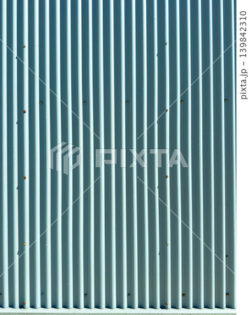 Metal wall with vertical lines and small marks captured during bright daylight at an outdoor location in a suburban area Metal wall with vertical lines and small marks captured during bright daylight at an outdoor location in a suburban area 139842310