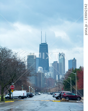 City skyline view from a street with trees and parked cars in Chicago during a cloudy day in late autumn 139842342
