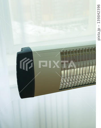 Heating unit installed near window with winter scenery outside at daytime 139842396