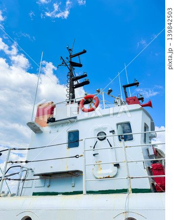 View of the upper deck of a boat showing equipment, safety features, and sky in the background during sunny weather at the harbor View of the upper deck of a boat showing equipment, safety features, and sky in the background during sunny weather at the harbor 139842503