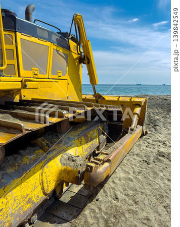 Heavy equipment works on the beach to reshape sand and prepare for upcoming activities near the ocean on a sunny day Heavy equipment works on the beach to reshape sand and prepare for upcoming activities near the ocean on a sunny day 139842549