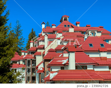 High buildings with red roofs against the clear sky in a mountain town during daytime 139842726