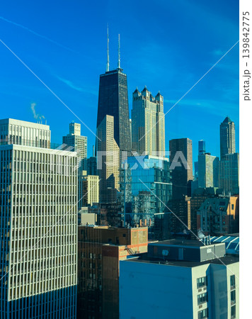 View from a window showing tall buildings in Chicago on a clear day during daytime hours with bright blue sky and some clouds View from a window showing tall buildings in Chicago on a clear day during daytime hours with bright blue sky and some clouds 139842775