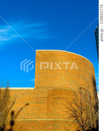 Bright blue sky above a large brick wall with a curved top in an urban area during daytime Bright blue sky above a large brick wall with a curved top in an urban area during daytime 139842778