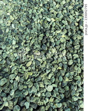 Small rocks cover the ground in a pattern at a construction site in the afternoon sun, showing various shapes and colors among the stones Small rocks cover the ground in a pattern at a construction site in the afternoon sun, showing various shapes and colors among the stones 139842795