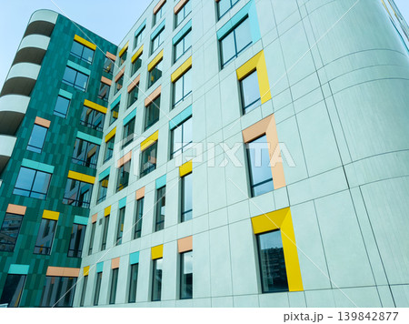 Colorful building design in an urban area showing modern architecture with windows and structured facade during daylight hours Colorful building design in an urban area showing modern architecture with windows and structured facade during daylight hours 139842877