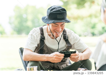 キャンプに来てゲームをする男性キャンパー キャンプに来てゲームをする男性キャンパー 139843205