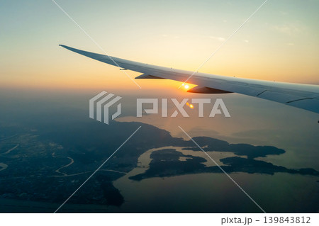 Airplane wing above Osaka coast during sunset descent flight Airplane wing above Osaka coast during sunset descent flight 139843812