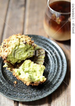 半分に割った抹茶チョコチップマフィンとアイスカフェオレ 139844243