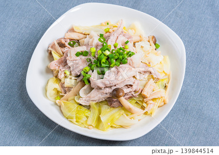 テーブルの上に置かれた豚こま肉とキャベツのフライパン蒸し テーブルの上に置かれた豚こま肉とキャベツのフライパン蒸し 139844514