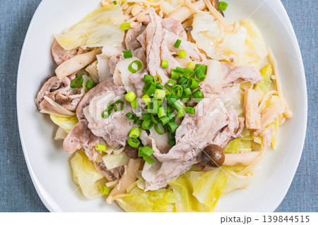 テーブルの上に置かれた豚こま肉とキャベツのフライパン蒸し テーブルの上に置かれた豚こま肉とキャベツのフライパン蒸し 139844515