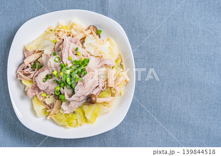 テーブルの上に置かれた豚こま肉とキャベツのフライパン蒸し 139844518