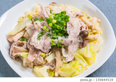 テーブルの上に置かれた豚こま肉とキャベツのフライパン蒸し テーブルの上に置かれた豚こま肉とキャベツのフライパン蒸し 139844519