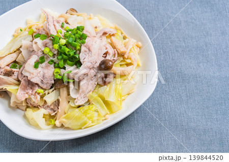 テーブルの上に置かれた豚こま肉とキャベツのフライパン蒸し 139844520
