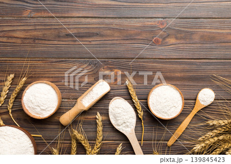 Flat lay of Wheat flour in wooden bowl with wheat spikelets on colored background. world wheat crisis 139845423