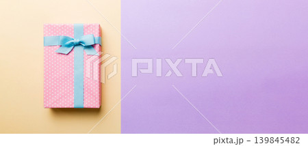 holiday handmade paper present tied blue ribbon bow top view with copy space. Flat lay holiday background. Birthday or christmas present. Christmas gift box concept with copy space holiday handmade paper present tied blue ribbon bow top view with copy space. Flat lay holiday background. Birthday or christmas present. Christmas gift box concept with copy space 139845482