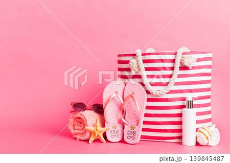 Stylish bag with beach accessories . Summer holiday concept. Top view of beach bag with sunscreen cream with space for text 139845487