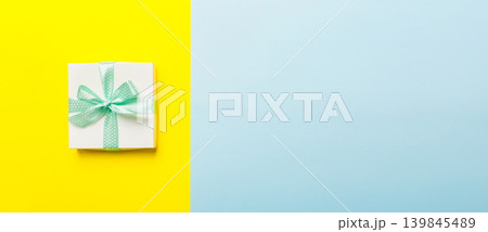 holiday handmade white present tied green ribbon bow top view with copy space. Flat lay holiday background. Birthday or christmas present. Christmas gift box concept with copy space 139845489