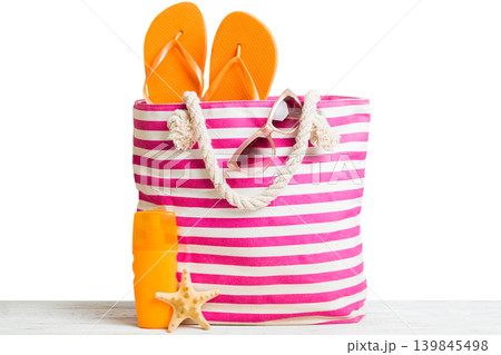Stylish bag with beach accessories . Summer holiday concept. Top view of beach bag with sunscreen cream with space for text Stylish bag with beach accessories . Summer holiday concept. Top view of beach bag with sunscreen cream with space for text 139845498