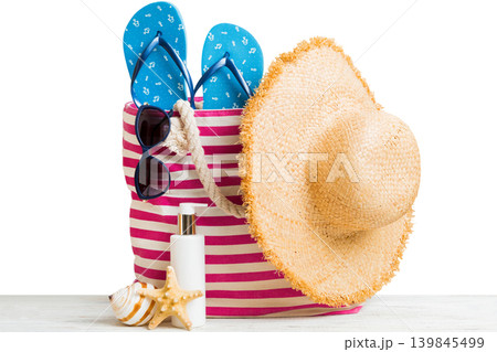 Stylish bag with beach accessories . Summer holiday concept. Top view of beach bag with sunscreen cream with space for text Stylish bag with beach accessories . Summer holiday concept. Top view of beach bag with sunscreen cream with space for text 139845499