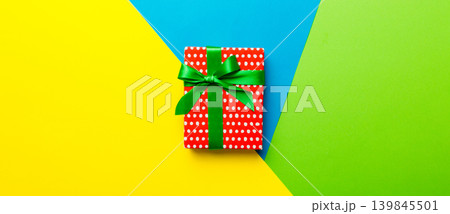 holiday paper present tied yellow ribbon bow top view with copy space. Flat lay holiday background. Birthday or christmas red present. Christmas gift box concept with copy space holiday paper present tied yellow ribbon bow top view with copy space. Flat lay holiday background. Birthday or christmas red present. Christmas gift box concept with copy space 139845501