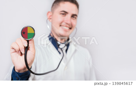 Doctor showing stethoscope with Guinea Bissau flag. Guinea Bissau national healthcare concept 139845617